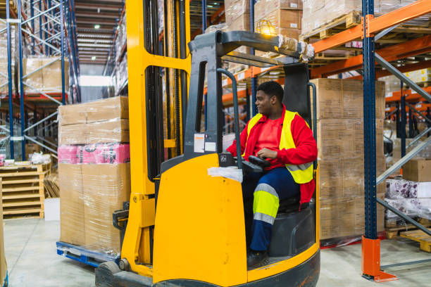 istock Warehouse worker driving forklift carrying goods in logistics center 2187866234