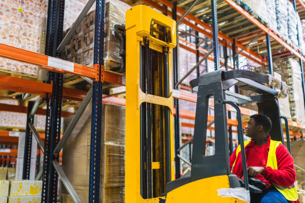 istock Warehouse worker operating forklift arranging goods on shelves 2187866265