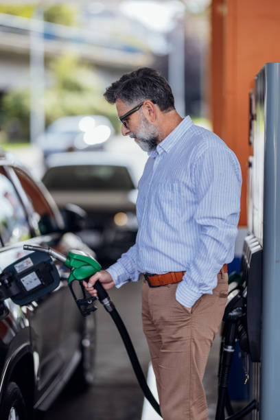 istock Man Refuels Car at Gas Station on a Bright Day 2187867810