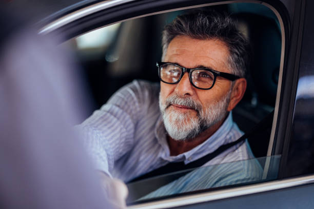 istock Mature Man in Glasses Smiling from Car Window 2187867854