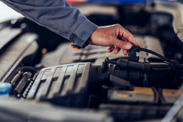 Mechanic's Hand Inspecting Car Engine for Maintenance and Repair