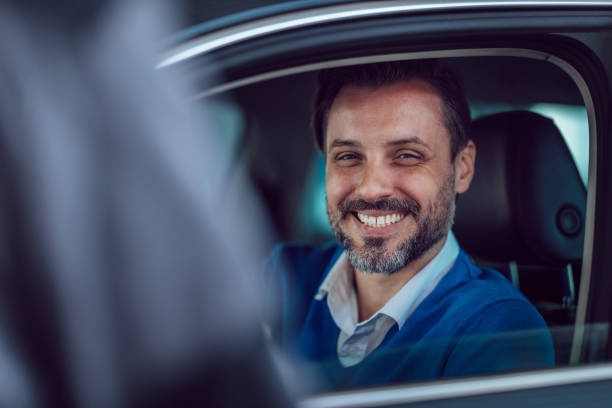 istock Smiling Man Sitting in Car Looking Through Open Window 2187867886