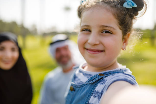 little kid take a selfie with the arab family