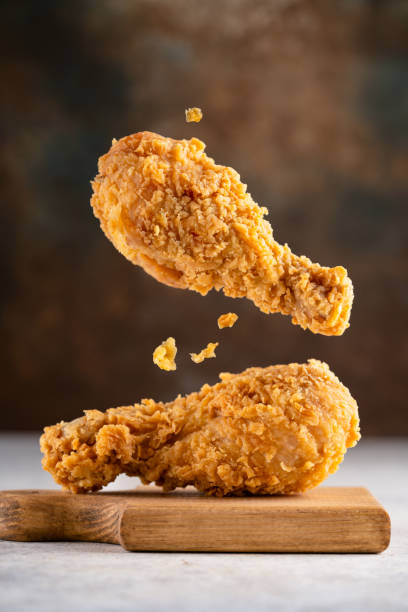 Delicious and crispy fried chicken legs on vintage  background