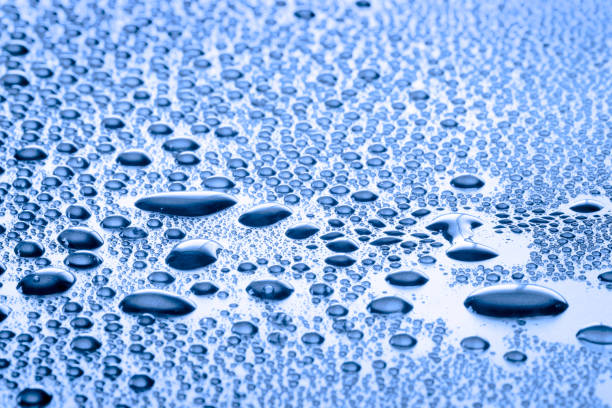 Micro droplets form a stunning pattern on a textured surface, highlighting nature's beauty in the morning light.