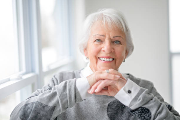 istock Portrait of elderly woman over grey background sit on sofa 2187869921