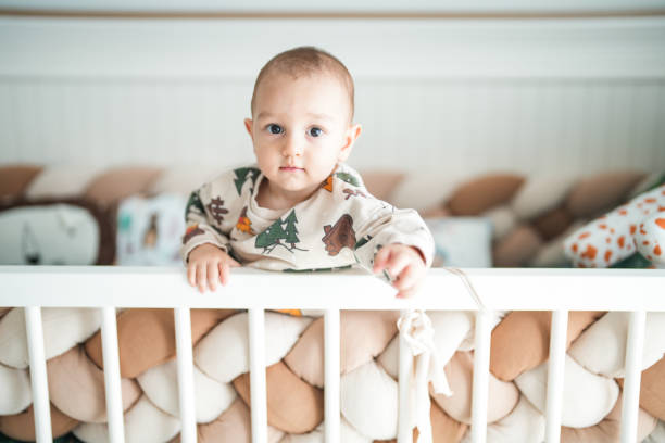 Baby boy playing in his crib at home