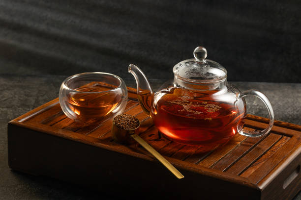 istock Tea ceremony on dark background. Tea pot and cup with  drink. 2187872797
