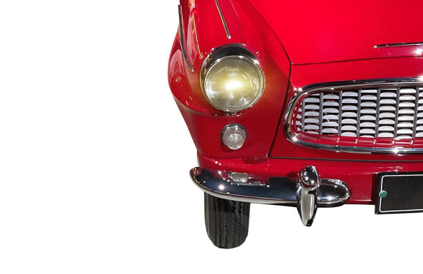 A detailed view of the front section of a vintage red car featuring iconic round headlights, chrome grille, and bumper, isolated on a white background, highlighting classic automotive design.