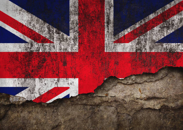 istock British Flag in Grunge Style, Damaged Paint on Rough Wall Background 2187876018