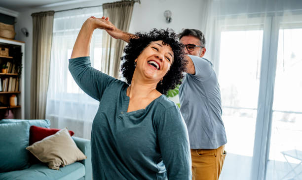 Mature couple dancing at home Happy playful mature couple dancing at home loving life stock pictures, royalty-free photos & images