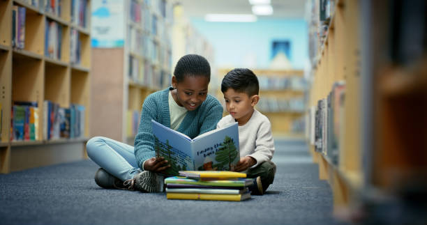 Children, books and reading in library for education, language development and peer support for learning. Friends, students and literature in school for storytelling, vocabulary growth and relax