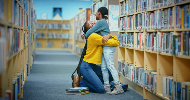 istock Hug, happy teacher or child in library for learning support, education or helping for development. Woman, teaching or African girl student with knowledge, love or care at middle school with smile 2187876931