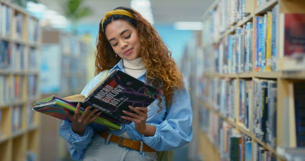 istock University student, reading books and woman in library for learning, science or microbiology at school. College, bookshelf or girl with textbook for education, knowledge or study for exam preparation 2187876974