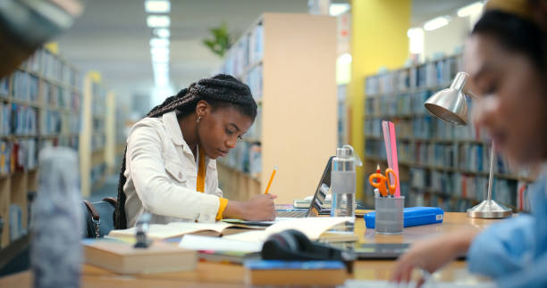 Writing, studying and notebook with woman in library for college research, education and project thesis. University student, knowledge and notes with person for scholarship, school and learning