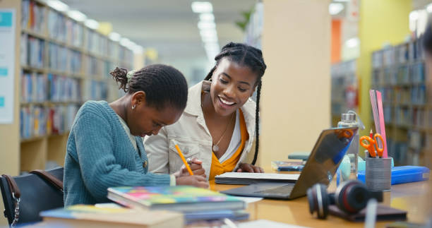 istock Woman, child and writing for education in library with learning support, language development and advice. Teacher, student and notebook with laptop for studying, assessment and information of tuition 2187877056