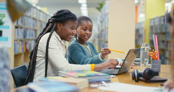 istock Teacher, girl and laptop for e learning in library with education support, information and advice. Woman, student and online research with studying, assessment and scholarship application for tuition 2187877058