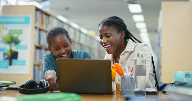 istock Woman, student and laptop for education in library with elearning support, information and advice. Teacher, child and online research with studying, assessment and scholarship application for tuition 2187877066