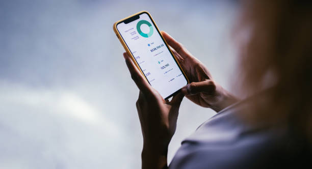 istock Close-Up of Hand Using Smartphone with Financial Data App 2187877945