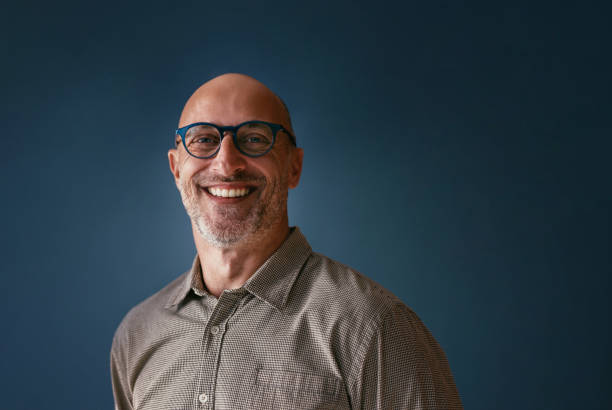 istock Smiling Man with Glasses Against a Blue Background 2187878001