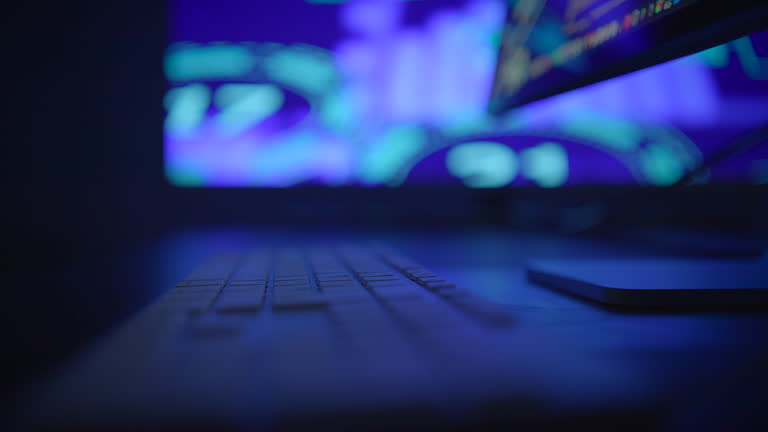 Fingers Rapidly Typing on a Keyboard Against a Bright Neon Background Displaying Colorful Lights