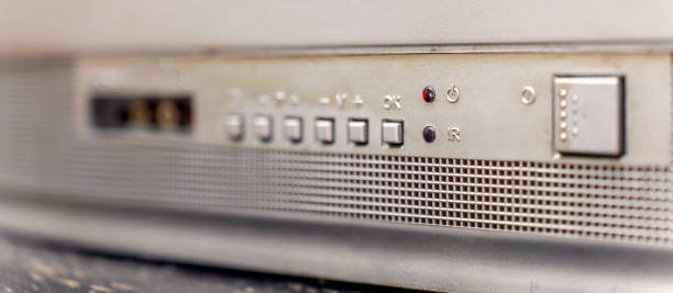 istock Detailed view of a vintage electronic device control panel with buttons, switches, and a perforated metallic speaker grille design 2187882941