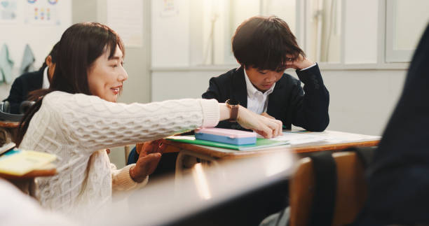 istock Japan, teacher and students in classroom, help and ideas with exams, teaching and learning. People, child and woman with education and development with stress, pressure and anxiety for test or adhd 2187885877