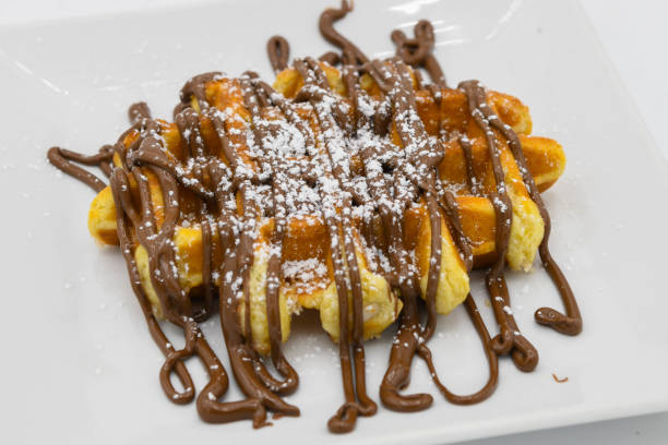 istock Belgian waffles with chocolate syrup on a white plate closeup 2187886362