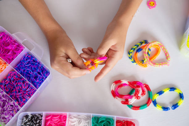 istock Colorful Loom Bracelets Being Crafted by Hand on White Background 2187889535