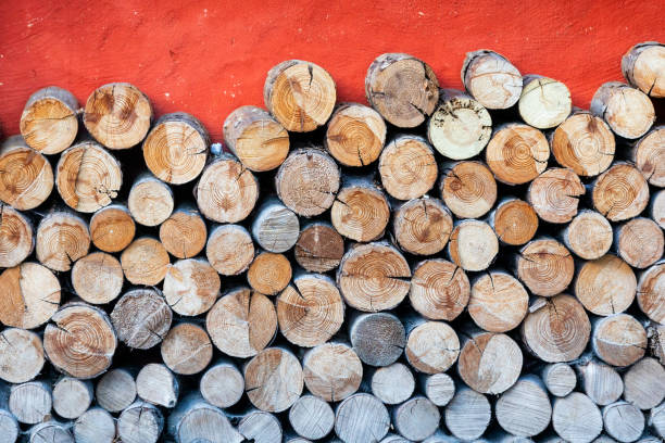 End view of stacked logs with red copy space.