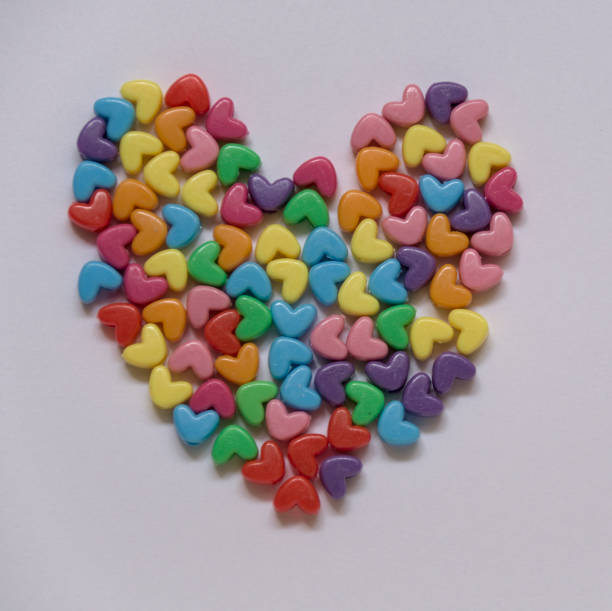 small multi colored hearts form a bigger heart, on white background