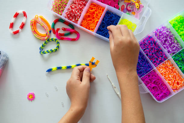 istock Crafting Colorful Loom Bracelets with Rainbow Bands on White Surface 2187893985