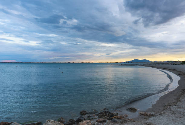 Last light of the day on the horizon with the sea covered in clouds on the beach of l'Ampolla, Catalonia.
