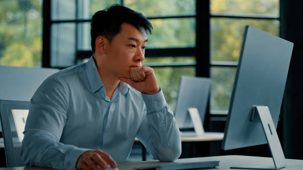 istock Asian businessman korean man work online at workplace difficult hard job get incorrect error in computer failure business problem. Upset anxious male disappointed about mistake bad internet in office 2187897340