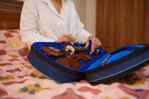 istock Person opening violin case on a bed with colorful patchwork quilt 2187897955
