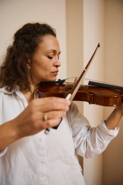istock Woman passionately playing violin in bright indoor setting 2187898044