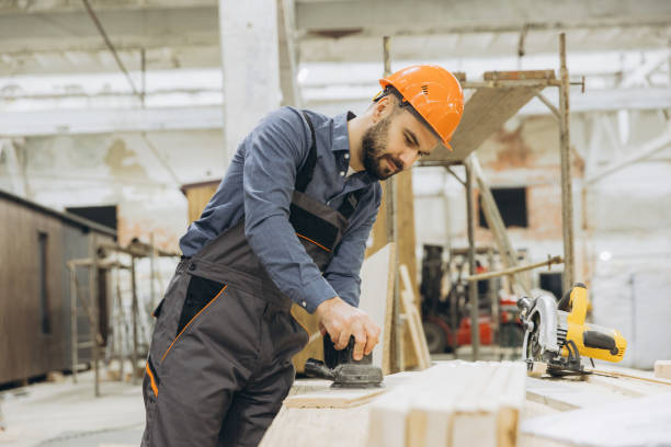 istock Carpenter sanding wooden plank in modular building factory 2187901038