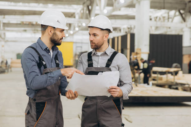istock Engineers discussing blueprint in modular building factory 2187901079