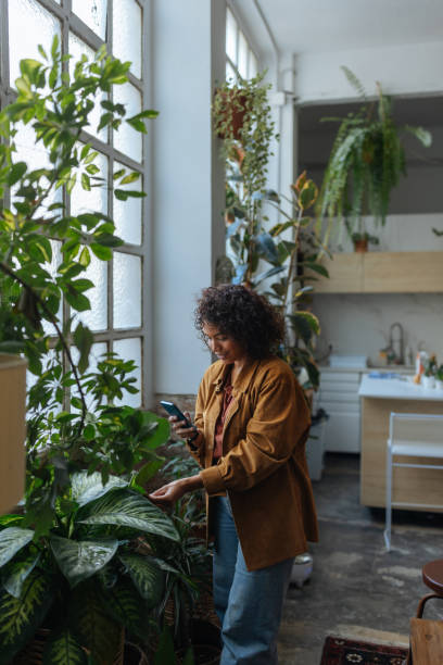 istock Woman checking her houseplants with a smartphone app 2187901960