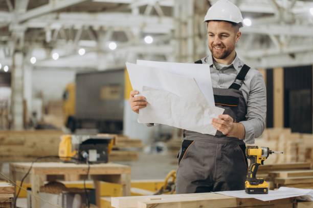 istock Construction worker reading blueprints in modular building factory 2187905000