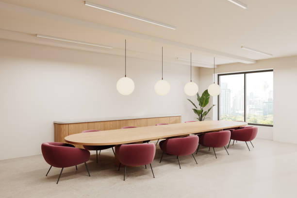 istock Spacious, modern conference room featuring a long wooden table, red chairs, and large windows with a city view. Bright, minimalist interior design. Concept of a corporate meeting space. 3D Rendering 2187906349