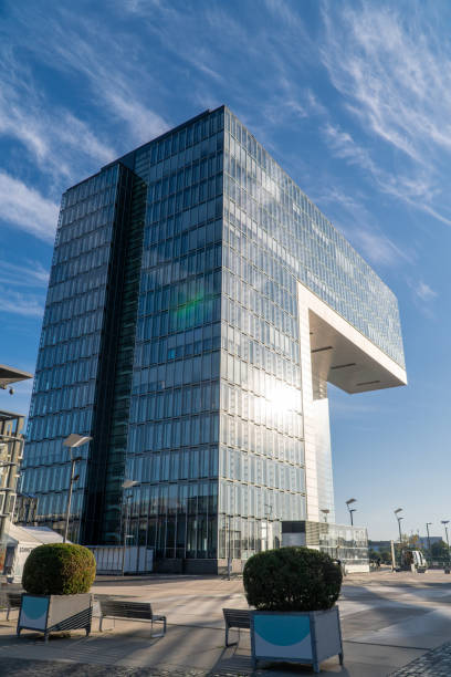 istock Modern riverside building with a unique architectural design reflects on the calm water under a clear blue sky. The warm sunlight highlights its structure and nearby surroundings. Landscape of Cologne 2187907040