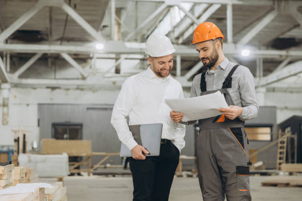 istock Engineers discussing blueprint in modular building factory 2187907927