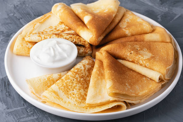 istock Stack of traditional russian pancakes blini with sour cream on gray background 2187910209