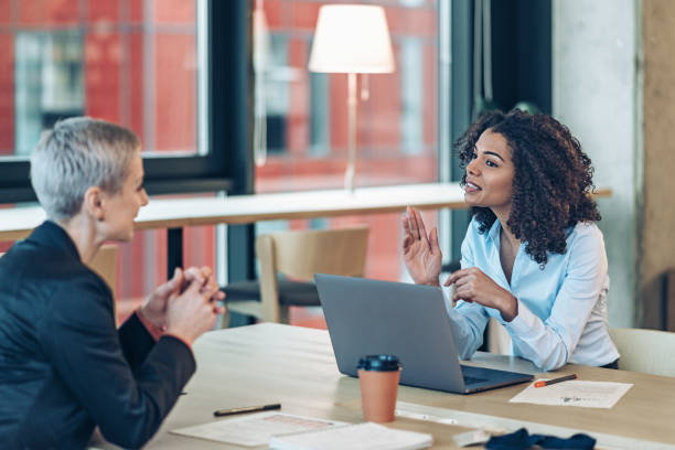 istock Two businesswomen talking in office space 2187918275