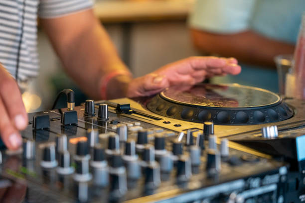 DJ Hands creating and regulating music on dj console mixer in concert