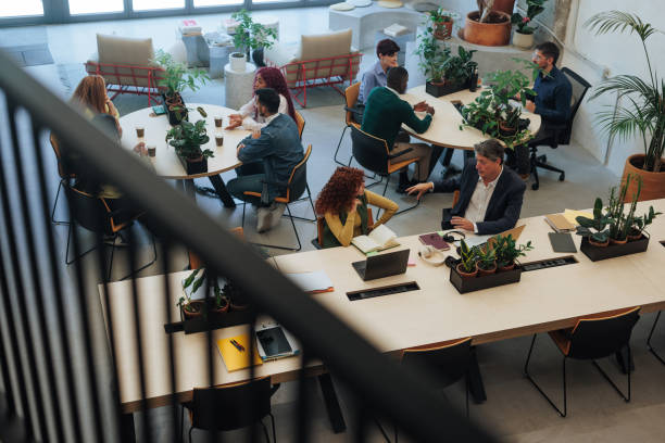 istock Coworkers collaborating and discussing projects in modern green office space 2187921939