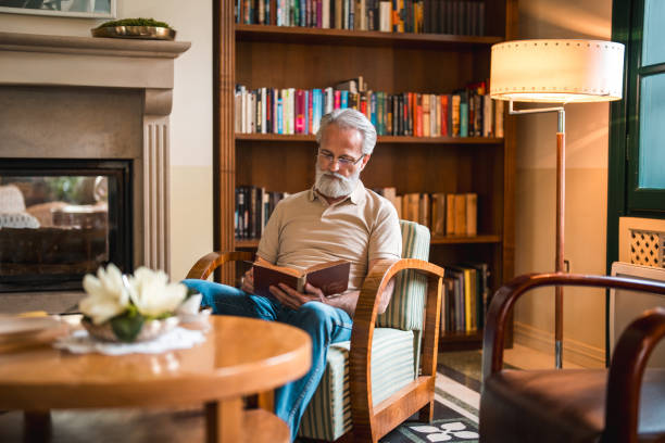 istock Senior Man Relaxing with Book and Coffee in Hotel Lounge 2187929021