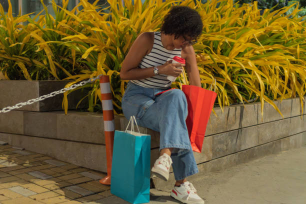 istock Young woman resting after shopping spree, enjoying a coffee break 2187933041