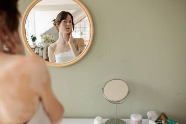 istock Young woman looking herself in the mirror 2187950243